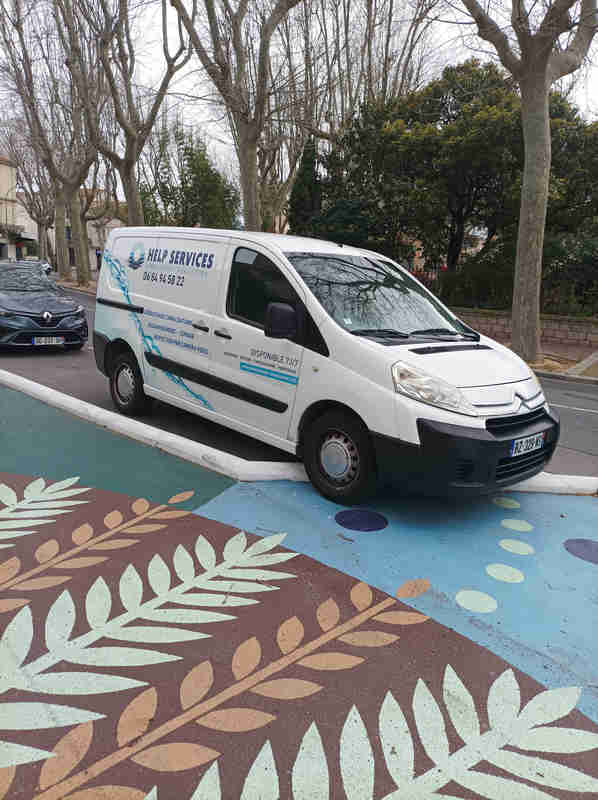Home Camionnette Help Services stationnée devant le Jardin de la Révolution à Narbonne