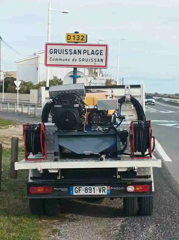 GRUISSAN Débouchage canalisation à Gruissan Plage avec camion hydrocureur HELP SERVICES devant panneau d’entrée