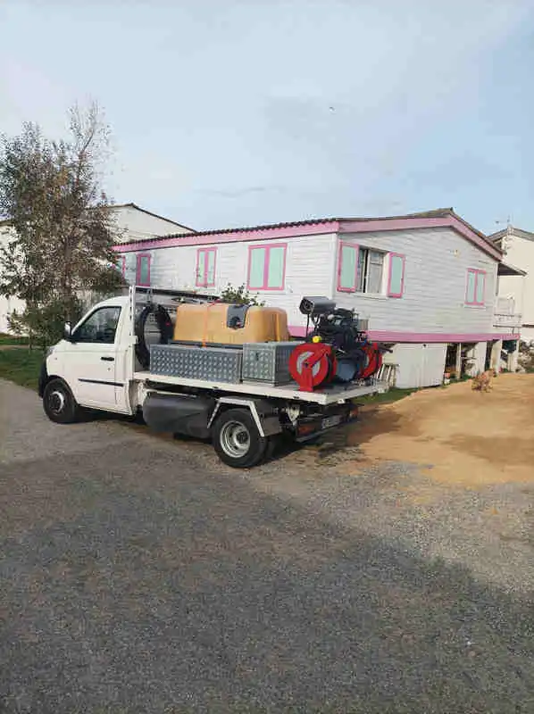 GRUISSAN Camion hydrocureur débouchage canalisation devant chalet traditionnel de Gruissan